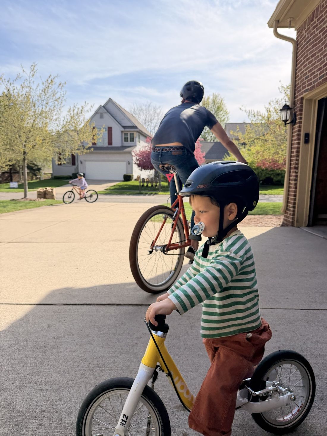 Kristian and his son riding bikes in their driveway